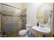 Well-lit bathroom featuring a glass-enclosed shower with tiled walls and a pedestal sink with round mirror at 14124 W Christy Dr, Surprise, AZ 85379