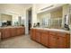 This bathroom features neutral tile, light walls, and a dual sink vanity with a large mirror at 14124 W Christy Dr, Surprise, AZ 85379