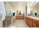 This bathroom features neutral tile, light walls, walk-in shower, a tub, and a dual sink vanity at 14124 W Christy Dr, Surprise, AZ 85379