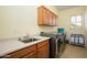 Well-equipped laundry room featuring a sink, cabinets, washer, and dryer for added convenience at 14124 W Christy Dr, Surprise, AZ 85379