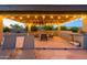 Covered outdoor kitchen with bar seating and a built-in grill, ideal for entertaining at 14124 W Christy Dr, Surprise, AZ 85379