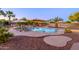 Outdoor pool featuring lounge chairs and umbrellas, surrounded by lush greenery for a private and tranquil setting at 14124 W Christy Dr, Surprise, AZ 85379