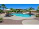 Resort-style pool featuring a rock waterfall, sundeck and a covered outdoor kitchen at 14124 W Christy Dr, Surprise, AZ 85379