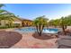 Stunning backyard with a freeform pool, lush landscaping, and a covered patio area at 14124 W Christy Dr, Surprise, AZ 85379