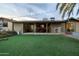 Backyard featuring artificial grass and patio with string lights and furniture at 14407 N 35Th Pl, Phoenix, AZ 85032