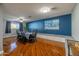 Bright dining room featuring hardwood floors, a blue accent wall, and a stylish dining set at 14407 N 35Th Pl, Phoenix, AZ 85032