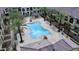 Aerial view of a community swimming pool surrounded by lounge chairs and palm trees, ideal for relaxation at 155 N Lakeview Blvd # 207, Chandler, AZ 85225