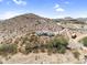 Desert home with a flat roof is nestled among native vegetation, offering privacy and views of the surrounding landscape at 1550 W Adobe Dam Dr, San Tan Valley, AZ 85144