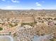 Wide angle aerial shot showing desert landscape, single story home, and surrounding neighborhood at 1550 W Adobe Dam Dr, San Tan Valley, AZ 85144