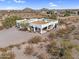 White home with a flat roof is nestled in the arid landscape, offering privacy and views at 1550 W Adobe Dam Dr, San Tan Valley, AZ 85144