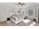 Bright bedroom featuring a decorative ceiling fan, hardwood floors, and a stylish bed with a patterned comforter at 1550 W Adobe Dam Dr, San Tan Valley, AZ 85144