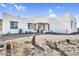 Single story modern home with a white exterior, a desert landscape, and a covered front patio with wooden posts at 1550 W Adobe Dam Dr, San Tan Valley, AZ 85144