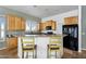 Modern kitchen with wood cabinetry, a breakfast bar, and tile flooring, designed for convenience at 1550 W Adobe Dam Dr, San Tan Valley, AZ 85144