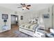 Cozy bedroom featuring a stylish bed, hardwood floors, and bright natural light from multiple windows at 1550 W Adobe Dam Dr, San Tan Valley, AZ 85144