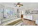 Sunlit main bedroom with hardwood floors, a ceiling fan, and large windows offering a bright and airy ambiance at 1550 W Adobe Dam Dr, San Tan Valley, AZ 85144