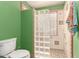 Bathroom featuring a toilet and tiled shower with glass block wall, and colorful decorative tiles at 15620 N 19Th St, Phoenix, AZ 85022