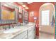 Bathroom featuring double sinks, decorative mirrors, bright paint, and a window with glass blocks at 15620 N 19Th St, Phoenix, AZ 85022