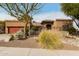 Charming home featuring a landscaped front yard with desert plants and a red garage door at 15620 N 19Th St, Phoenix, AZ 85022