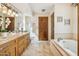 Refined bathroom featuring a double vanity with granite countertops, framed mirrors, and a tiled jacuzzi tub at 16611 E Inca Ave, Fountain Hills, AZ 85268