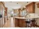 Traditional-style kitchen with wood cabinets, granite countertops, an island with seating, and hardwood floors at 16611 E Inca Ave, Fountain Hills, AZ 85268