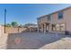 Large gravel backyard featuring a stucco wall, covered patio, and the rear facade of a two-story home at 17025 W Rimrock St, Surprise, AZ 85388