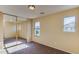 Bedroom featuring mirrored closet doors, tan walls, carpet flooring, and natural light from two windows at 17025 W Rimrock St, Surprise, AZ 85388