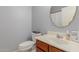 Bathroom featuring a round mirror, wood cabinet, and white sink at 18842 N Lariat Rd, Maricopa, AZ 85138