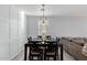 Elegant dining area with a modern light fixture, wood-look floors, and wainscoting at 18842 N Lariat Rd, Maricopa, AZ 85138