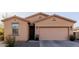 Charming single-story home with a tan exterior, a two-car garage, and simple desert landscaping at 18842 N Lariat Rd, Maricopa, AZ 85138