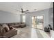 Bright living room featuring an oversized sectional sofa, neutral decor, and sliding glass doors to the backyard at 18842 N Lariat Rd, Maricopa, AZ 85138