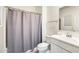 Bright bathroom features a gray shower curtain, white vanity, and neutral decor at 2228 W Harmont Dr, Phoenix, AZ 85021