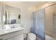 Bright bathroom featuring a large vanity, toilet, and shower-tub combination with a stylish blue curtain at 2228 W Harmont Dr, Phoenix, AZ 85021