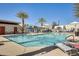 Sparkling community pool with lounge chairs, a covered picnic area, and lush palm trees at 2228 W Harmont Dr, Phoenix, AZ 85021