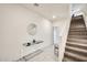 Bright entry hallway with tile flooring, carpeted staircase, and a decorative mirror on the wall at 2228 W Harmont Dr, Phoenix, AZ 85021