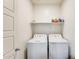 Functional laundry room with a side-by-side washer and dryer and a shelf for storage at 2228 W Harmont Dr, Phoenix, AZ 85021