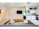 Living area featuring a textured white accent wall, TV, and built-in bar with white cabinets at 2228 W Harmont Dr, Phoenix, AZ 85021