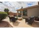 A tranquil backyard patio setup with outdoor chairs, a fire pit and desert landscaping at 2509 E Dulcinea Trl, Casa Grande, AZ 85194