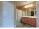 This bathroom features a large mirror with vanity lighting, a shower with curtain, and two mats at 2509 E Dulcinea Trl, Casa Grande, AZ 85194