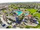 Aerial view of a community pool area with splash pad, slides, playground, covered seating, and green spaces at 2509 E Dulcinea Trl, Casa Grande, AZ 85194