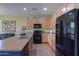 This kitchen has stainless steel appliances and black appliances, wood cabinets, and beautiful tile flooring at 2509 E Dulcinea Trl, Casa Grande, AZ 85194