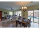 The view from the dining table to the living room shows the open concept and the sliding door to the pool at 2509 E Dulcinea Trl, Casa Grande, AZ 85194