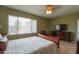 This main bedroom features a large window, ceiling fan, a wooden dresser and a cozy chair at 2509 E Dulcinea Trl, Casa Grande, AZ 85194