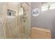 Close up of travertine tiled shower with glass door, built-in niche, and shower caddy at 2712 S Tambor --, Mesa, AZ 85209