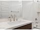 Modern bathroom vanity featuring quartz countertop, a stainless steel faucet, and wood-tone cabinetry at 27280 N 74Th Ln, Peoria, AZ 85383