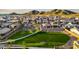 An aerial view of the community park featuring a large green lawn, walking path, and desert trees at 27280 N 74Th Ln, Peoria, AZ 85383