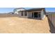 Rear view of home showcasing covered patio, sliding glass doors, and expansive backyard at 27288 N 74Th Ln, Peoria, AZ 85383