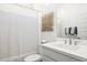 Clean bathroom featuring a white sink, decorative wall art, and a shower with a curtain at 27288 N 74Th Ln, Peoria, AZ 85383