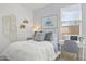 Bright bedroom featuring patterned wallpaper, a cozy bed, and a well-lit desk area at 27288 N 74Th Ln, Peoria, AZ 85383