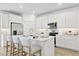 Bright kitchen with white cabinets, stainless steel appliances, quartz countertops, and a central island with barstool seating at 27288 N 74Th Ln, Peoria, AZ 85383