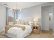 Bedroom with a soft headboard, modern chandelier, geometric wallpaper, and coordinated furniture at 27288 N 74Th Ln, Peoria, AZ 85383